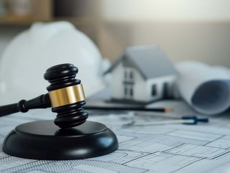 Labor and Construction law concept.judge gavel with white safety hat,blueprint,home model backgound.Government service protecting safety at job. Worker security protection policy.